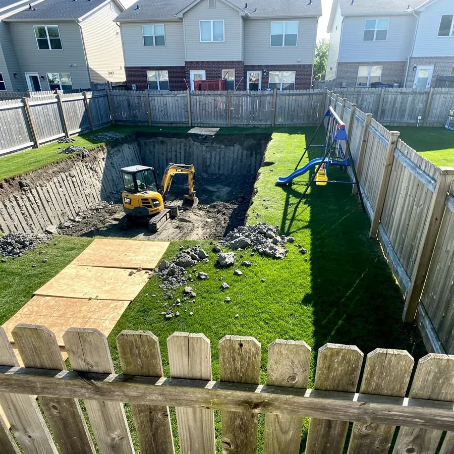 Mini excavator digging pool in Milton backyard