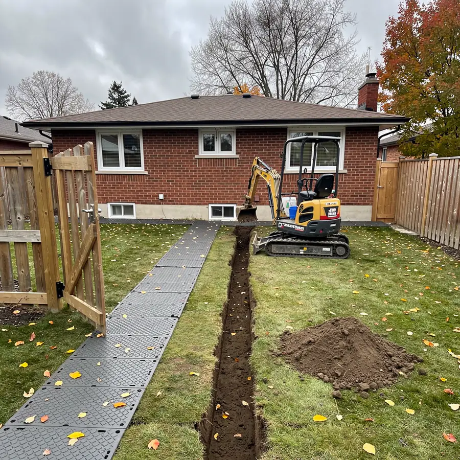 Mini excavator on mats in Guelph backyard